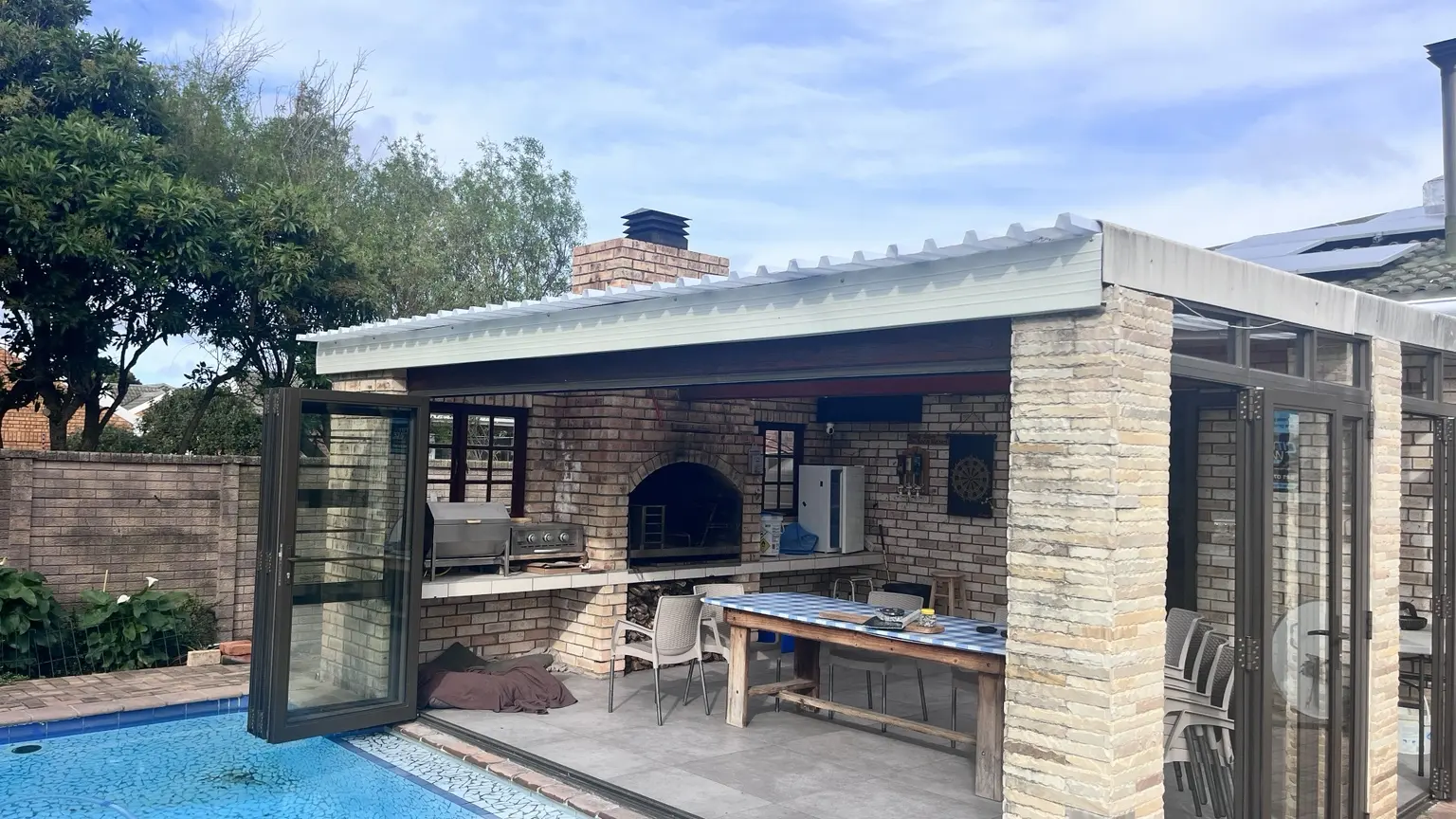 Completed covered entertainment area with white roofline finish